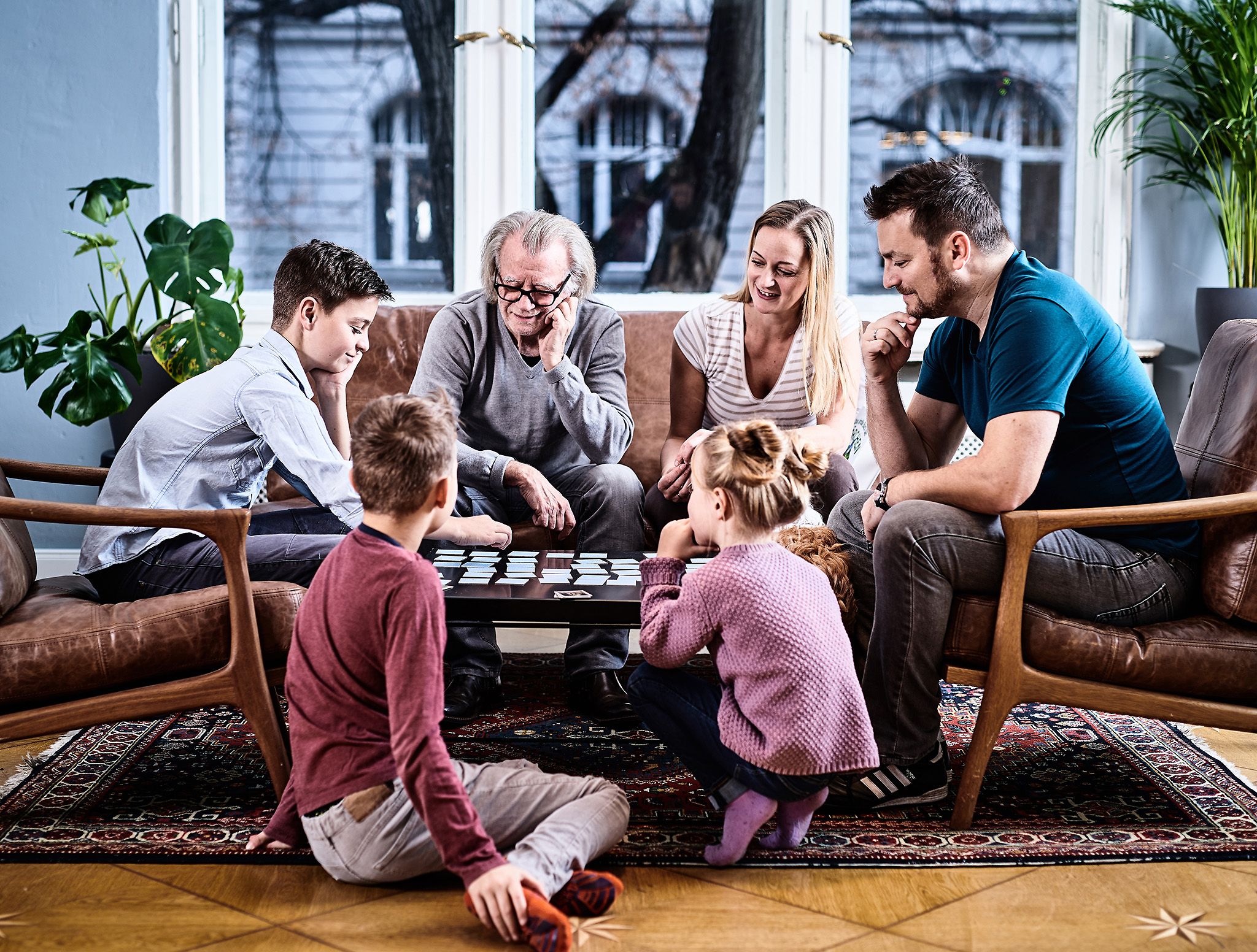 Eine Familie sitzt am Tisch und spielt 